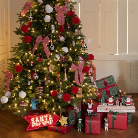 A luxurious artificial Christmas tree from Floralsilk, styled in an elegant living room with soft festive lighting